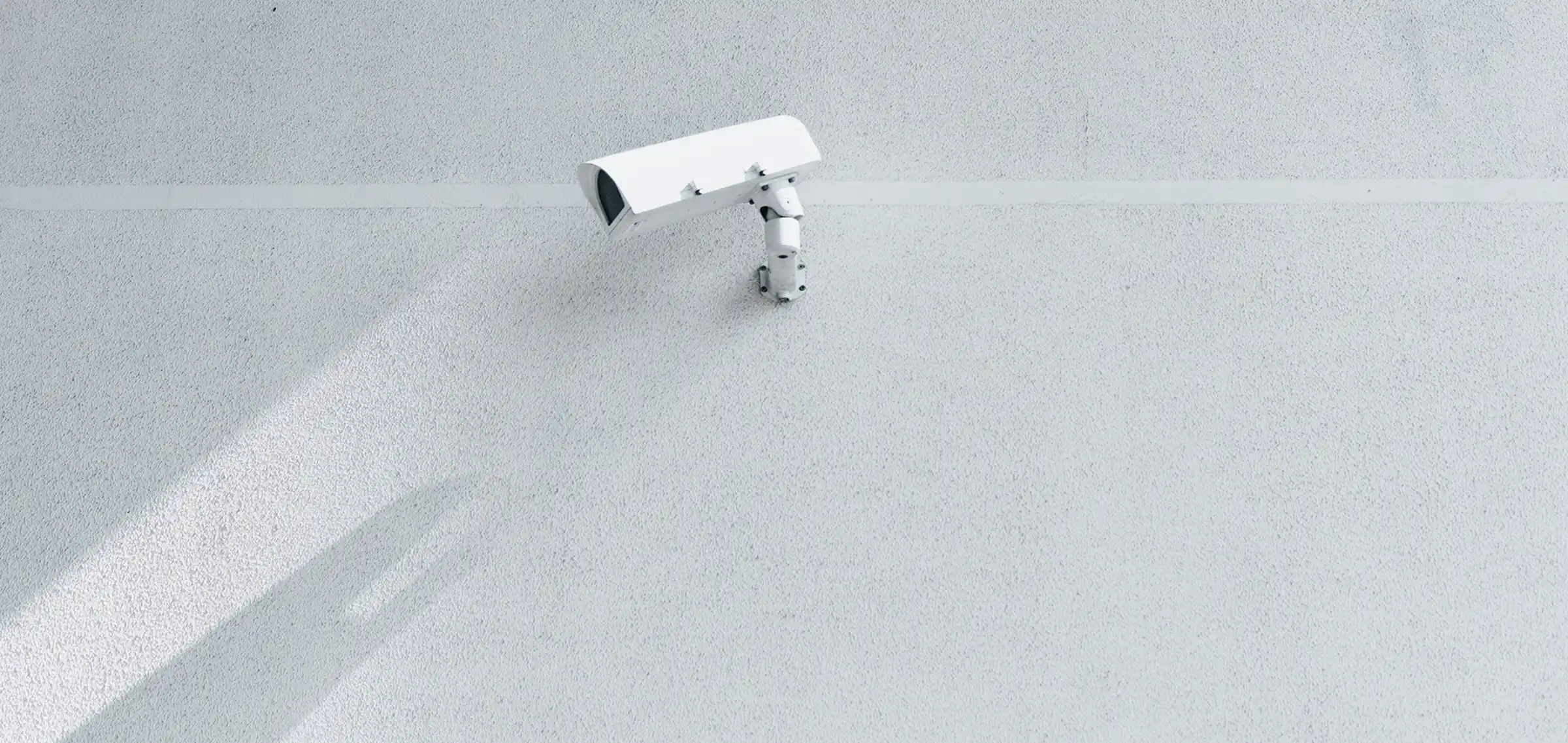 Background: a surveillance camera mounted on a wall