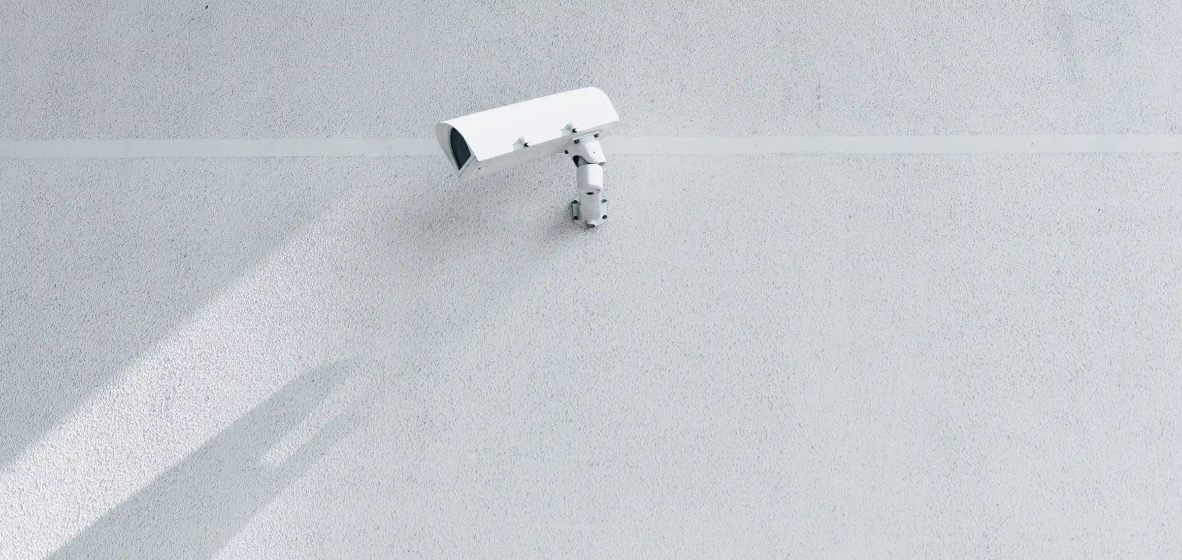 Background: a surveillance camera mounted on a wall